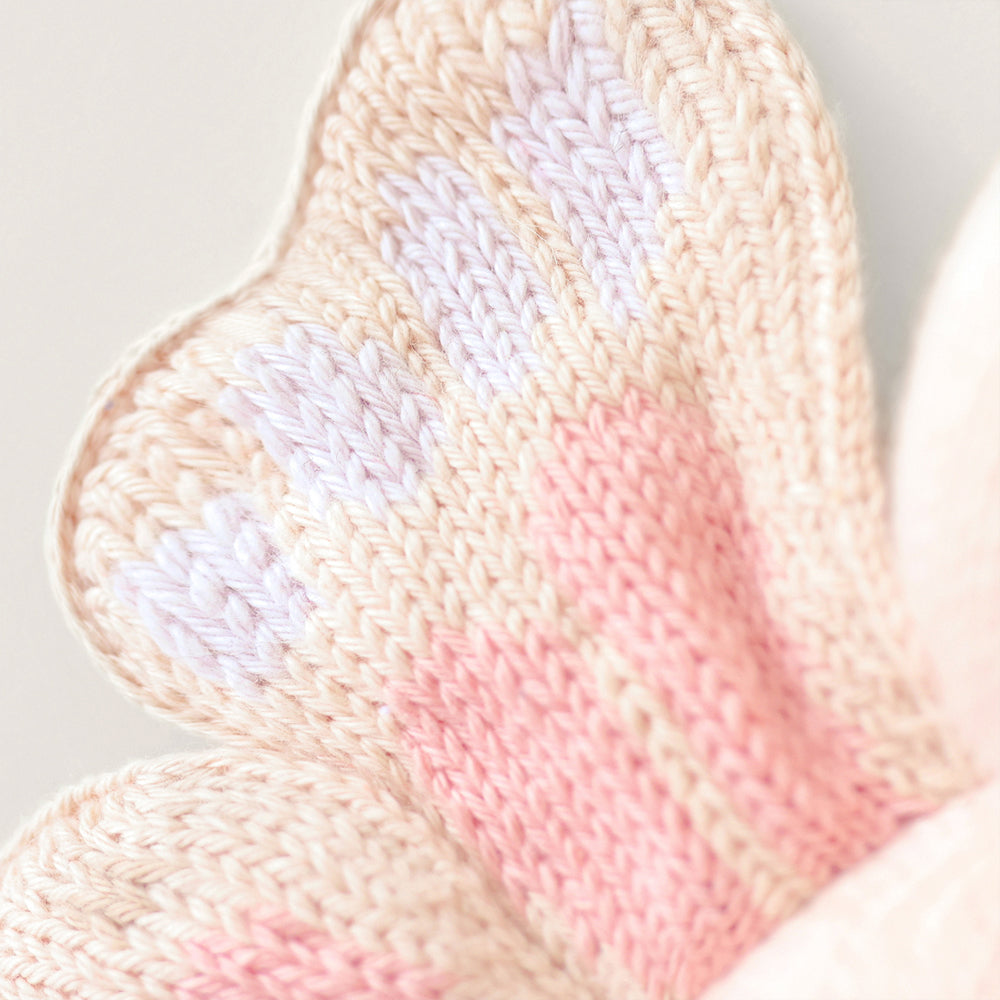
                  
                    Close-up of Cuddle + Kind Baby Butterfly (Petal Pink), showing delicate hand-knit wing detail in soft pink and cream tones.
                  
                