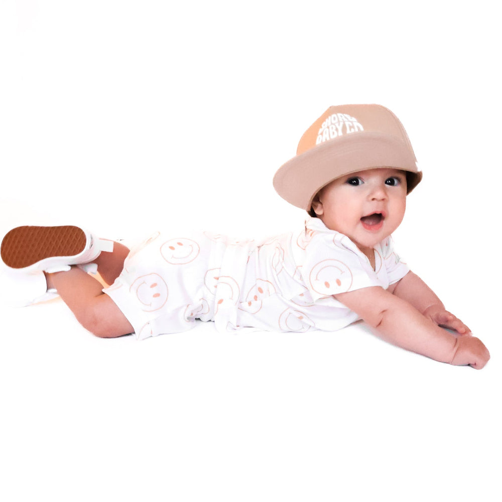 
                  
                    Photo of a baby boy wearing a white shirt and shorties set adorned with camel-colored smiley faces, ideal for toddlers. The design features ribbed bamboo fabric, ensuring comfort and breathability. Available sizes include 3-6 months, 6-12 months, 12-18 months, and 18-24 months, making it a versatile and stylish choice for both boys and girls.
                  
                