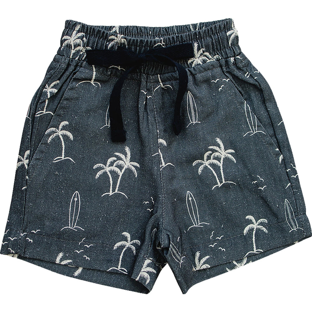 Flat lay of Mebie Baby Navy Surfer Linen Cotton Shorts, dark blue shorts with palm tree and surfboard print, elastic waistband, and black drawstring, displayed on white background.