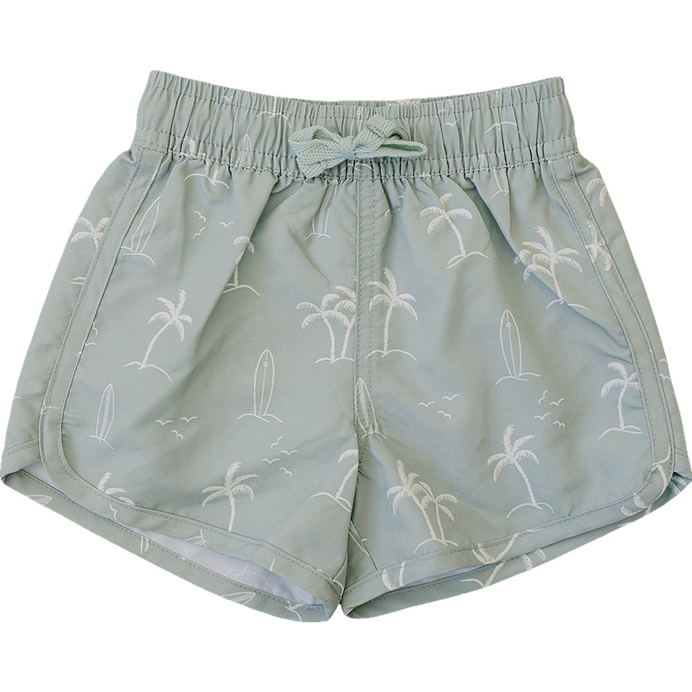 Flat lay of Mebie Baby Sage Surfer Swim Shorts, light green swim shorts featuring white palm tree, surfboard, and seagull pattern, displayed on a white background.