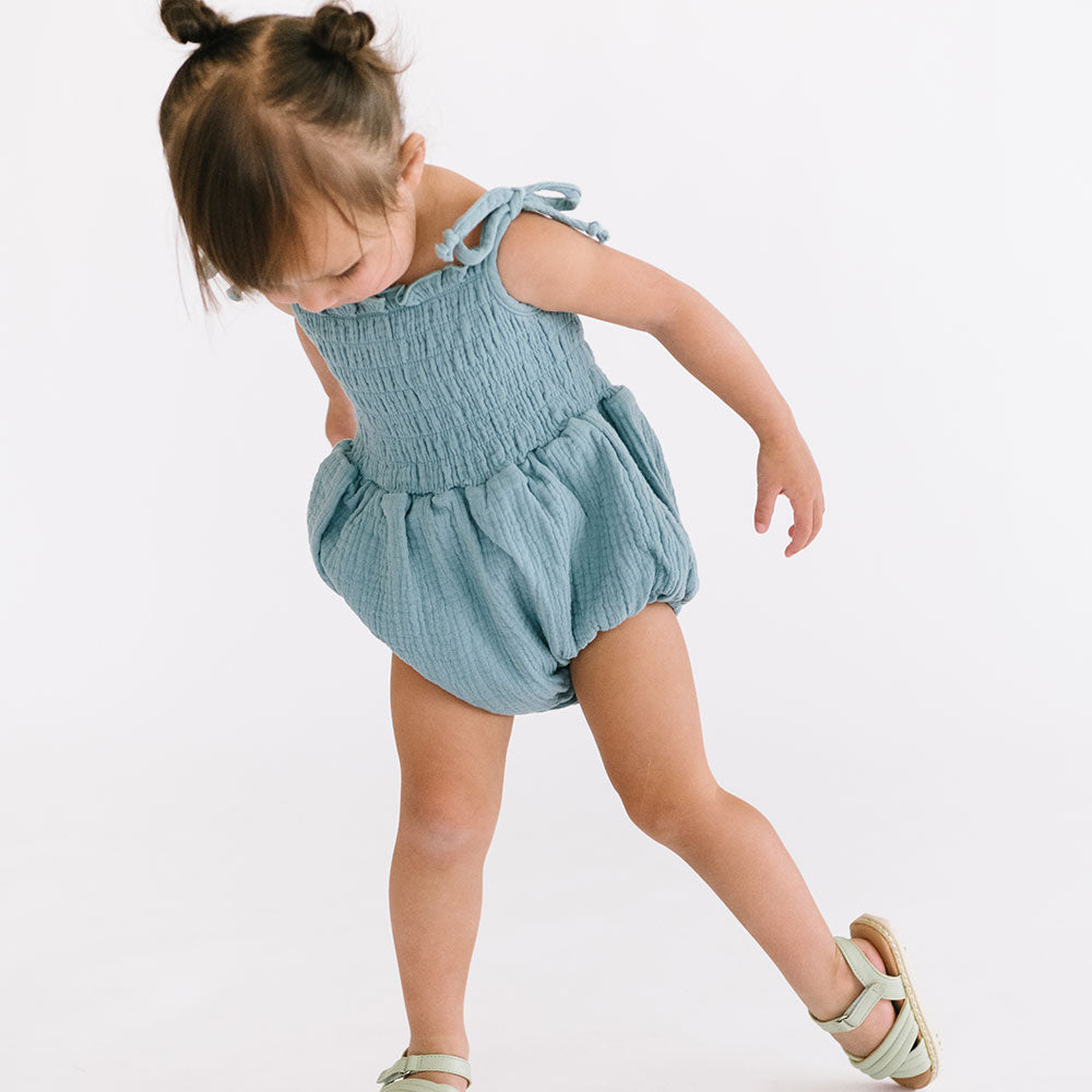 
                  
                    The Smocked Onesie in Aegean Blue
                  
                